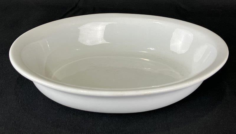 Cockson & Sedan Ironstone Bowl: Pristine white ironstone bowl by Cockson & Seddon, showcasing a simple, elegant design. Measures approximately 2 1/8" H x 10 1/4" W x 8" D. Minor discoloration and surface markings consistent with age