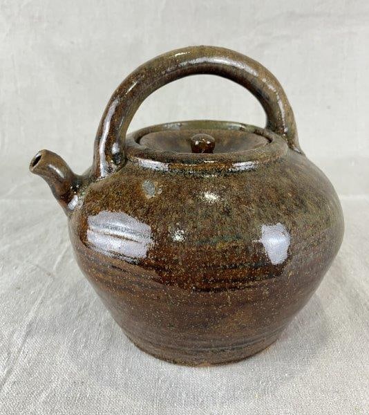 Alkaline Glaze Teapot: Rich, colorful glaze with turned spout and applied handle, removable lid, and visible throwing lines along the sides. Measures approximately 7" H x 7 1/4" W x 6 1/2" D. Good condition.