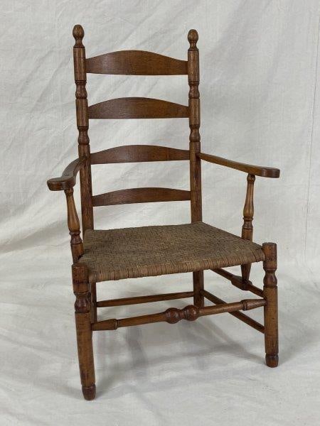 Southern Great Chair: Turned back posts with twin urns and finials, arched slats, and front posts each featuring an urn. Arm supports are ornately turned, complemented by a large front stretcher and a finely woven split oa