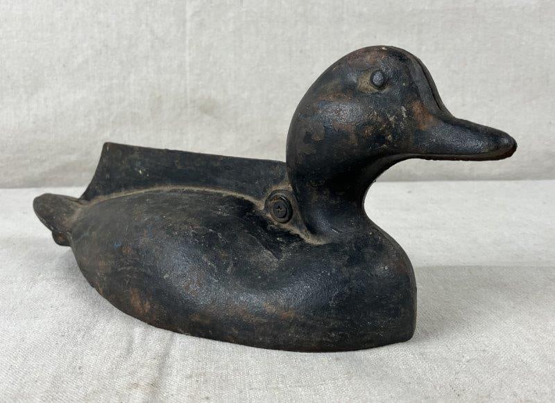 Cast Iron Duck Boot Scraper: Black painted cast iron duck-form boot scraper with aged patina. Measures approximately 4 7/8'' x 4 1/4'' x 11 1/2''. Wear to paint and areas of surface rust.