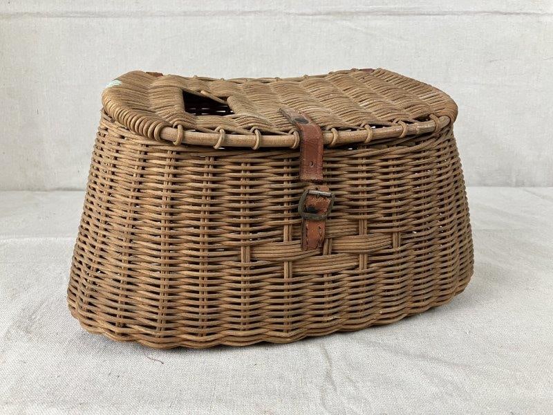 Antique Fishing Basket: Nicely woven wicker fishing basket with a wrapped rimmed lid and back handle, showing a warm aged patina. Measures approximately 13 5/8" H x 5 7/8" W x 7 5/8" D. Good condition with wear consistent wi