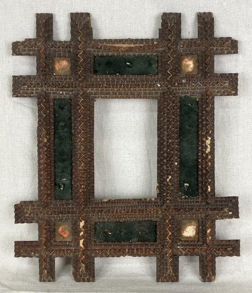 Tramp Art Wood Frame: Characteristic dimensional and layered wood carving from a skilled independent artisan. Measures approximately 14 5/8" H x 12 1/2" W x 3/4" D. Some wood loss to edges and wear/loss to inset fabrics.