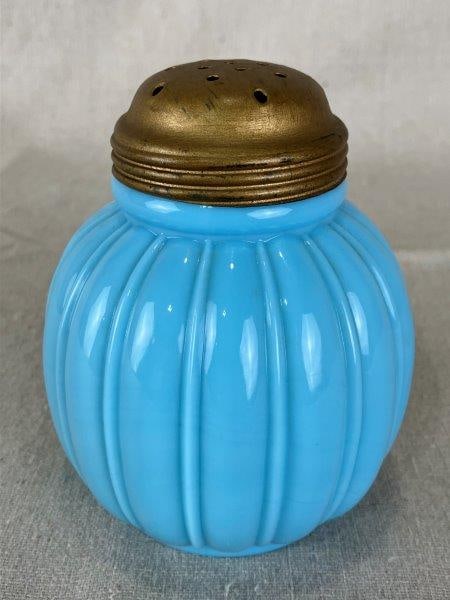 Blue Milk Glass Muffineer: Featuring elegant curved fluting and a rounded, robust form. Measures approximately 5" H x 3 1/4" in diameter. Good condition with minimal wear and small abrasions to interior.