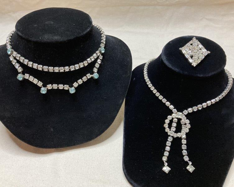 Pair of Crystal Rhinestone Necklaces and Pendant: A grouping of vintage jewelry comprising two necklaces and a pendant, each set with light-reflective crystal rhinestones in classic arrangements. One necklace measures approximately 14 3/8 " in length