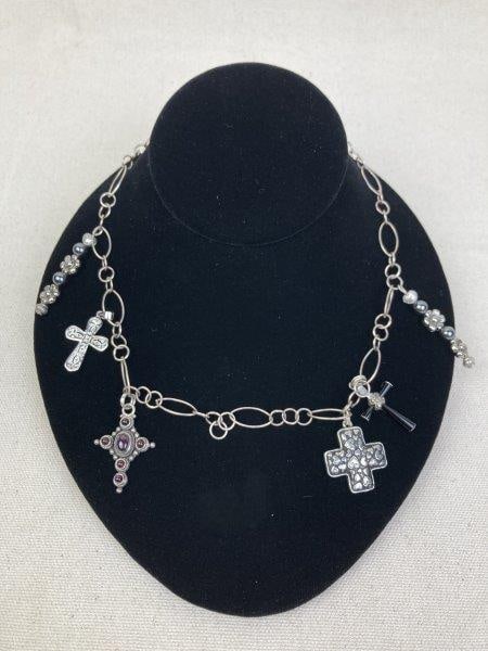 Sterling Silver Necklace with Cross Charms: Sterling silver link chain necklace adorned with multiple cross charms, including one with heart-shaped details and others set with stones such as garnet and onyx with marcasite. Two beaded charms acc