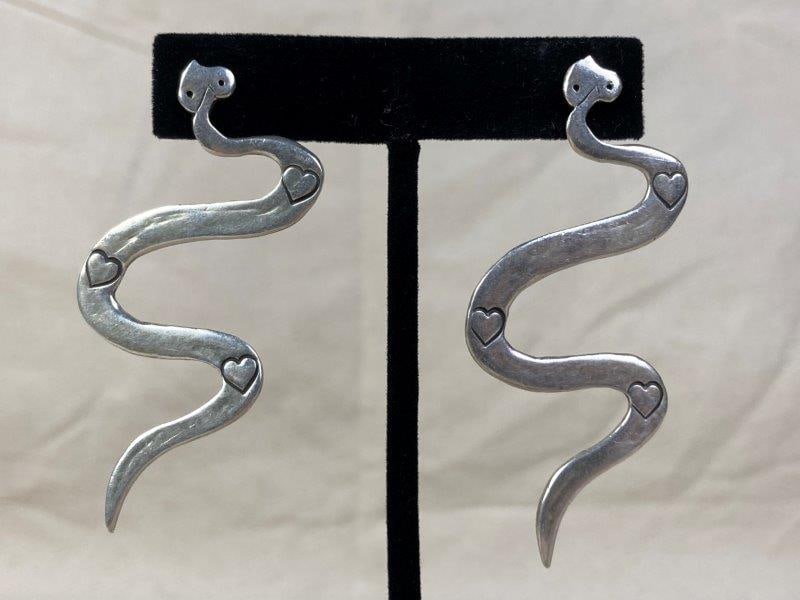 Sterling Silver Native American Snake Earrings: Sterling silver earrings engraved with heart-shaped accents, crafted in a snake motif. Marked 925 and stamped Daslin. Each measures approximately 1 1/2" wide with a 2 1/2" drop. In good condition with