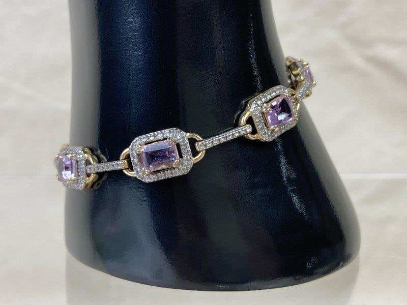 Sterling Silver Bracelet: Sterling silver bracelet set with baguette-cut pink quartz stones, accented with gold-tone details and clear quartz highlights. Stamped 925 China on clasp. Measures approximately 7 3/4" long. In good