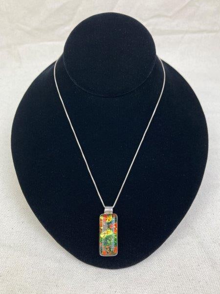 Sterling Silver Necklace with Dichroic Glass Pendant: Mid century modern style pendant of vibrant dichroic glass featuring shimmering gold, green, and black patterns over a red base. Both pendant and chain are stamped 925 and marked Italy. The chain meas