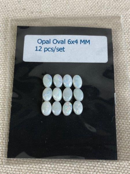 Set of 12 Opal Oval Gemstones: Collection of twelve oval-cut opals displaying fiery white play-of-color. Each gemstone measures approximately 6 x 4 mm. In good condition.