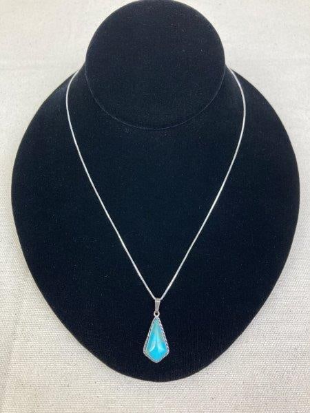 Sterling Silver Necklace with Turquoise Pendant: Sterling silver necklace featuring a kite-shaped turquoise pendant displaying a striking golden matrix within the stone. Both pendant and chain stamped 925. Chain measures approximately 17 1/2" long; 