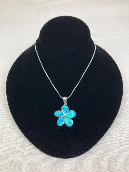 Sterling Silver Necklace with Blue Opal Plumeria Pendant: A Hawaiian-inspired sterling silver necklace showcasing a finely crafted plumeria flower pendant inlaid with vibrant blue opal. The opal exhibits striking color play, shifting from oceanic blues to tr