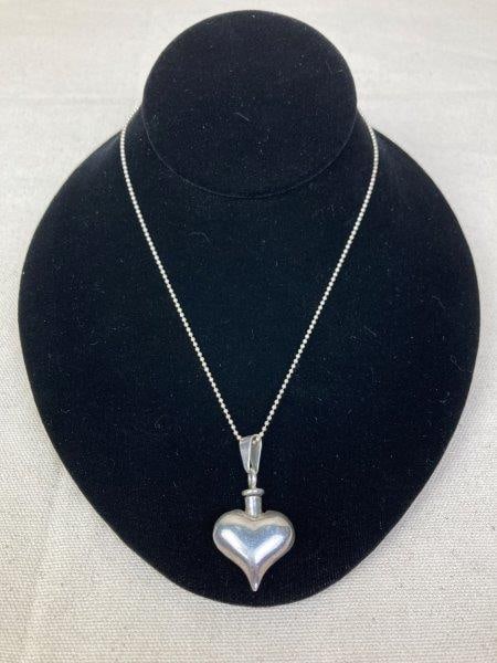Sterling Silver Heart-Shaped Perfume Bottle Necklace: Sterling silver chain suspending a heart-shaped perfume bottle pendant with delicate detailing. Pendant marked Mexico 925. Chain measures approximately 20" long. In good condition with light wear cons