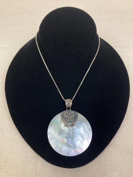 Sterling Silver Necklace with Mother-of-Pearl Pendant: Sterling silver necklace featuring a luminous mother-of-pearl pendant, stamped 925 on the reverse, suspended from a chain stamped .925 Italy on the clasp. Chain measures approximately 16" long. In goo