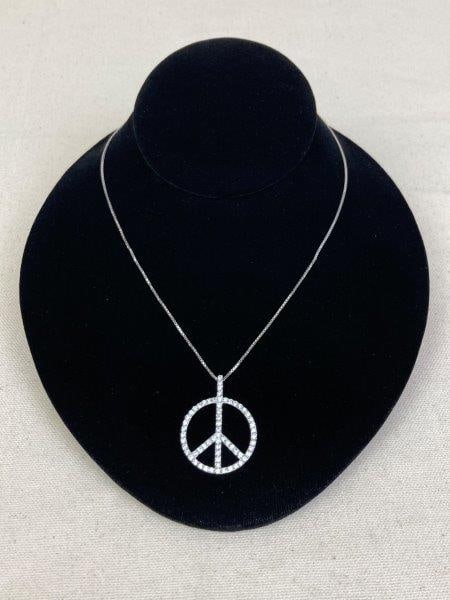 Sterling Silver Necklace with Peace Sign Pendant: A stylish sterling silver necklace showcasing a peace sign pendant accented with sparkling diamond-like gemstones that catch the light beautifully. Marked 925 Italy. Chain measures approximately 16". 