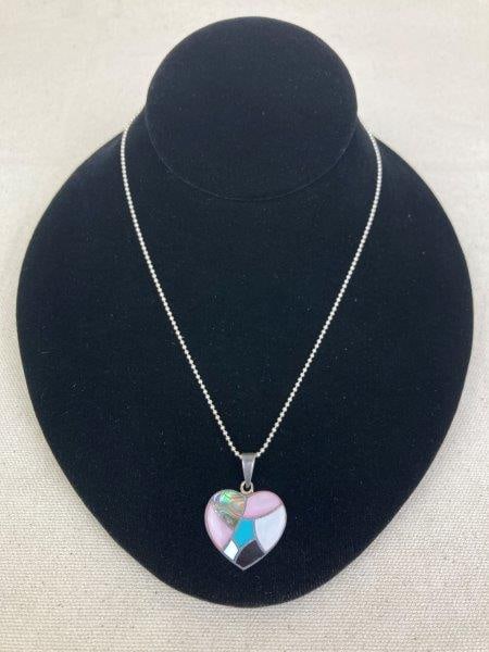 Sterling Silver Heart Necklace with Mosaic Inlay: A striking sterling silver heart-shaped pendant intricately inlaid with a vibrant mosaic of iridescent mother-of-pearl, shimmering abalone, and polished onyx, creating a colorful and eye-catching desi