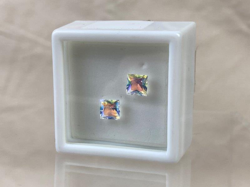 Moonglow Mystic Topaz Gemstones: Beautiful pair of faceted Moonglow Mystic Topaz gemstones, each weighing approximately 1.4 carats for a total of 2.80 carats. Exhibiting brilliant iridescent tones and ready to be set. Good condition.