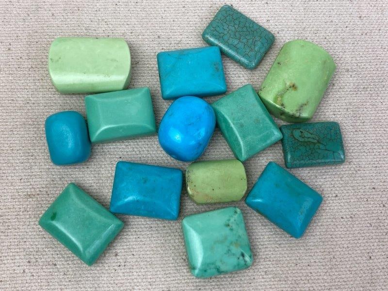 Group of Turquoise Beads: Collection of pre-threaded turquoise beads in various shapes, sizes, and hues ranging from light blue to deep green. Each bead displays natural matrix patterns and polished surfaces. In good condition
