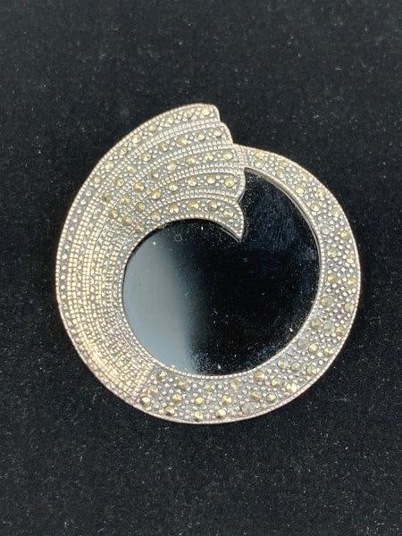 Art Deco-Style Sterling Silver Brooch: Elegant Art Deco-style brooch crafted in sterling silver, centered with a polished black onyx cabochon and accented with sparkling marcasite details. Stamped 925 on the back. Measures approximately 1