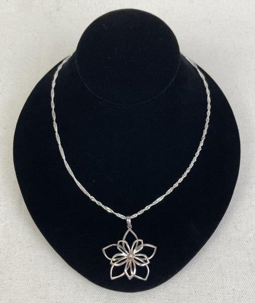 Sterling Silver Open Flower Pendant Necklace: Elegant sterling silver necklace featuring an openwork flower pendant suspended from a delicate twisted link chain. Chain stamped 925 Italy and measures approximately 18" long; pendant stamped 925 on