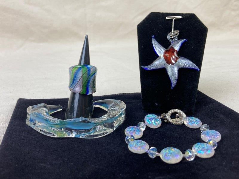 Lot of Art Glass Jewelry: Colorful collection of art glass jewelry including a bangle measuring 3 1/8" in diameter, a starfish-shaped pendant measuring 2 1/8" wide, an art glass bead bracelet measuring 7 1/2" long, and a ring,