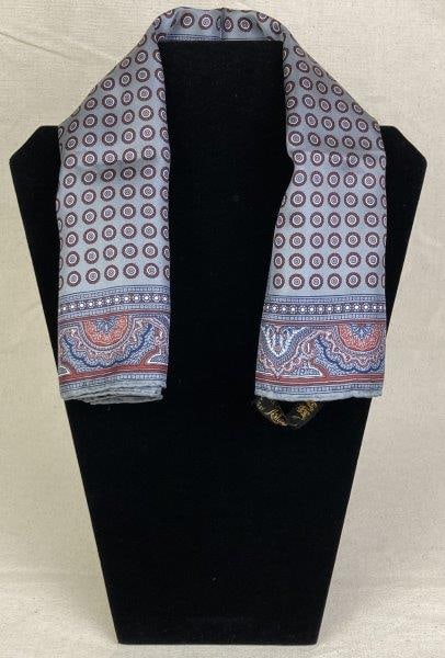 Ashear Silk Scarf: Refined Ashear silk scarf featuring an elegant design of miniature round medallions in tones of gray, red, and blue, framed by a complementary border. Made in Italy with hand-rolled edges finished in