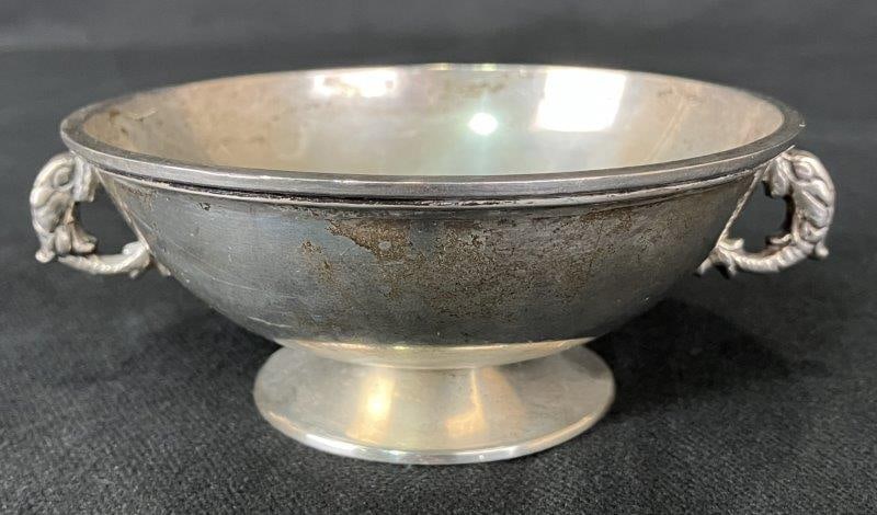 Sterling Silver Pedestal Bowl with Dolphin Handles: Charming sterling silver pedestal bowl featuring ornate dolphin-form handles and a reflective surface, traditionally used as a wedding bowl. Marked 900 on the base denoting silver content, and made in