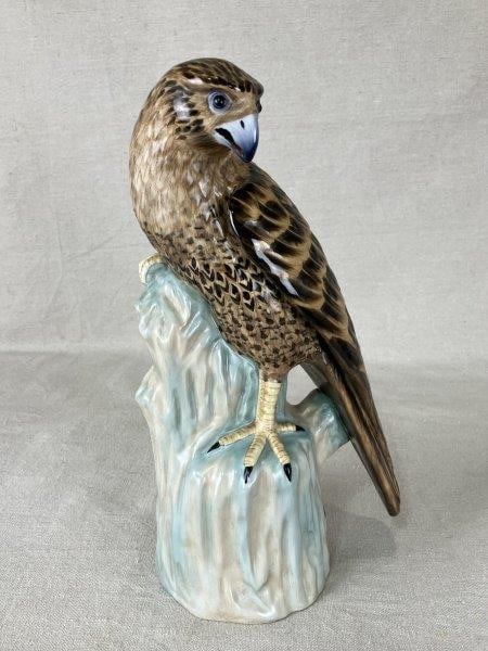 Chelsea House Porcelain Falcon Sculpture: Elegant porcelain sculpture by Chelsea House, featuring a falcon in richly detailed brown tones, gracefully perched upon an aqua-toned rock. Measures approximately 11 1/2" H x 5 5/8" W x 4" D and is i