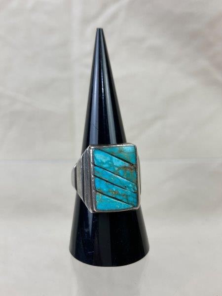 Men’s Sterling and Turquoise Ring: Handsome vintage sterling silver ring featuring a polished turquoise cabochon accented by incised line details flanking each side. Ring size 9. Good condition.