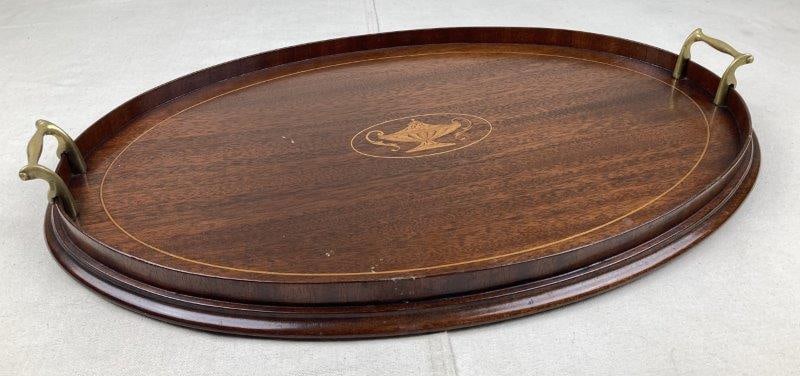 Mahogany Inlaid Butler’s Tray: Elegant mahogany butler’s tray featuring a central oval inlaid urn motif and fitted with brass side handles. Measures approximately 24'' x 15''. Condition: Good overall with light wear consisten