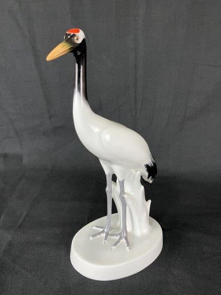 Noritake Nippon Porcelain Crane: Elegant porcelain crane figurine by Noritake Nippon, finely modeled and decorated in striking red, orange, black, and white tones on a highly polished surface. A graceful example of Japanese artistry.