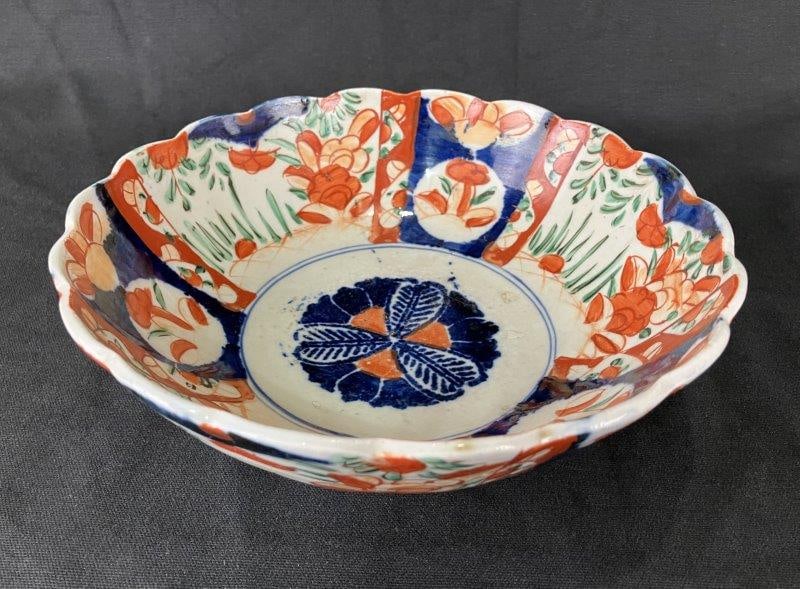 Japanese Imari Porcelain Bowl: Classic Imari porcelain bowl decorated with vibrant characteristic colors and intricate design elements, exemplifying traditional Japanese craftsmanship. Measures approximately 3 3/8" H x 9 1/2" in di