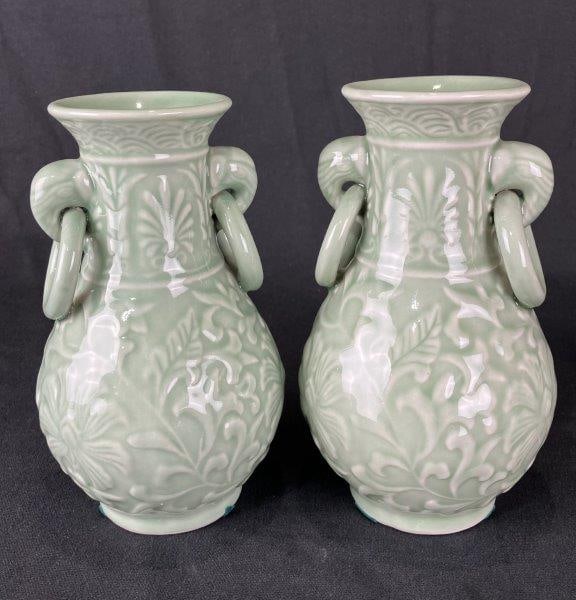 Pair of Celadon Porcelain Vases: Coordinating pair of porcelain vases decorated with floral motifs and finished in a classic celadon glaze, showcasing refined craftsmanship and timeless appeal. One measures approximately 7 1/4" H x 3
