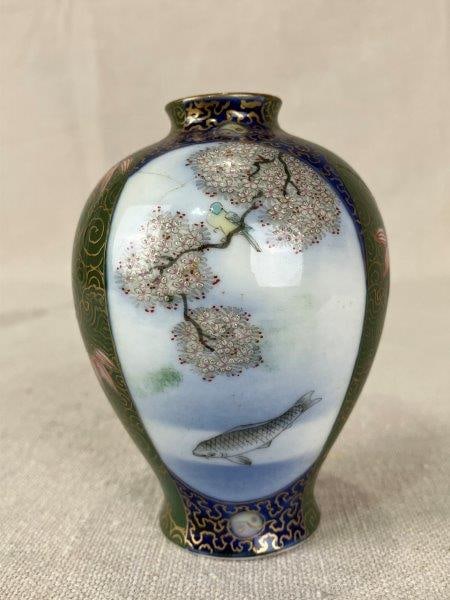 Japanese Hand-Painted Porcelain Vase: Delicate Japanese porcelain vase, hand-painted with flowers on one side and a fish in the water with a bird perched in a tree on the other, executed in a palette of predominant blues and greens. Measu
