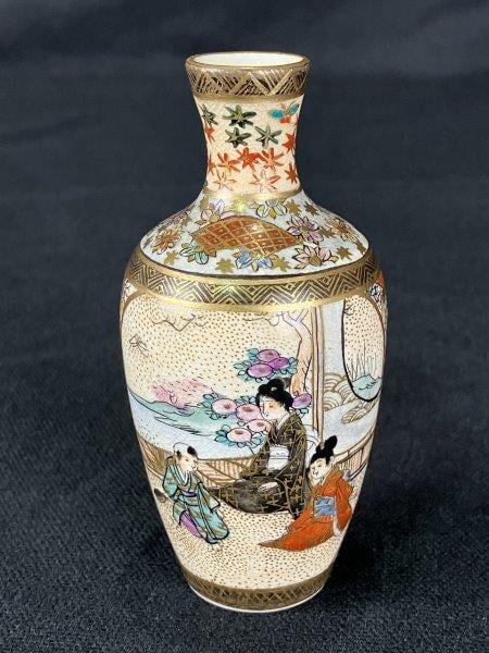 Japanese Satsuma Vase with Figural Motifs: Delicate petite Satsuma vase, hand-painted with intricate figural motifs: one side depicting a woman with two children in a domestic setting within a verdant landscape, and the reverse showing two mal