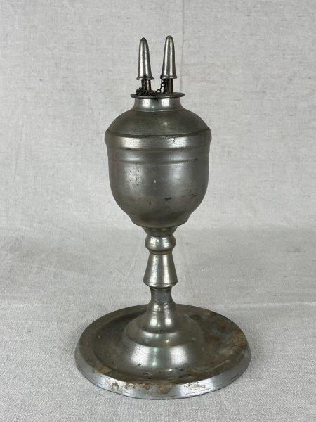 Pewter Whale Oil Burner Lamp: Handsome pewter whale oil burner lamp with an elegant curving form, exuding old-world charm and craftsmanship. Measures approximately 9 1/4" H x 5 1/4" in diameter. Some spotting and markings consiste