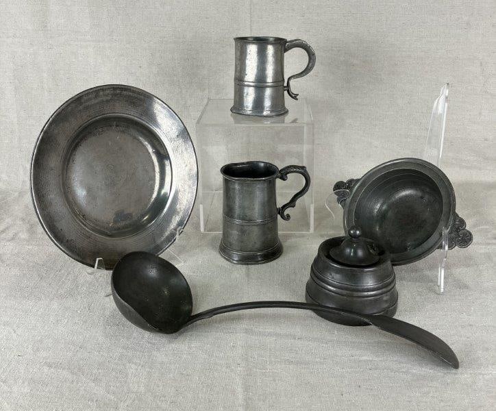 Pewter Assortment: Collection of pewter items showcasing old-world charm and artisan craftsmanship. The plate measures approximately 3/4" H x 8 1/8" in diameter. Some bends, darkening, and minor wear throughout, consist