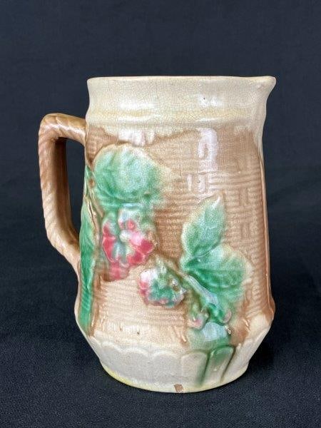 19th Century Majolica Floral Motif Pitcher: Charming majolica pitcher featuring a basket-weave pattern adorned with mauve and green floral decoration, executed in the traditional 19th-century majolica style. Measures approximately 5 3/4" H x 4 