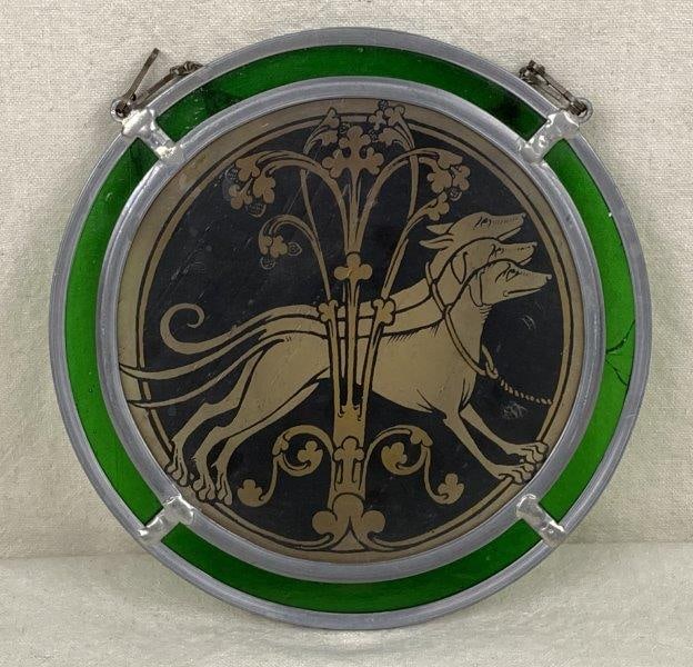 Celtic Stained Glass Suncatcher: Beautiful stained glass suncatcher featuring a central design of three hounds with a floral motif, surrounded by green glass panels and suspended by a chain. Measures approximately 14 1/4" H x 7 7/8"