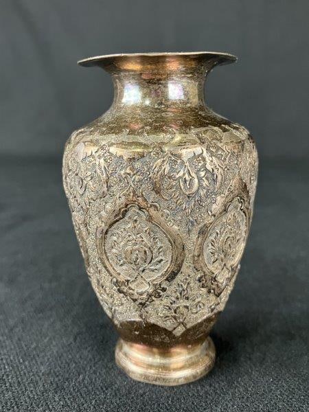 Silverplate Vase with Eastern Motif: Silverplate vase decorated with intricate floral repoussé adornments, reflecting Eastern-inspired design elements and fine decorative metalwork. Measures approximately 3 1/4" H x 1 7/8" in diamet