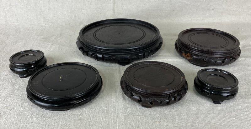 Chinese Carved Wooden Stands: Grouping of carved wooden display stands featuring both mahogany and lacquer finishes, ideal for showcasing porcelain or decorative objects. The largest measures approximately 1 3/4" H x 8" in diamete