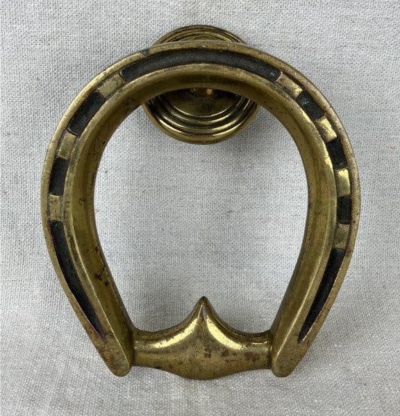 Brass Horseshoe Door Knocker: Elegant brass door knocker in the distinctive form of a horseshoe, displaying a warm and polished surface that highlights its decorative appeal. Measures approximately 5 3/4" H x 4" W x 1 3/4" D. Show