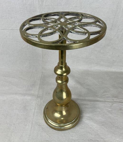 Tall Brass Trivet: Elegant brass trivet featuring a distinctive interlocking design on the top and a warm, lustrous surface throughout. Measures approximately 15" H x 8 1/2" in diameter. Some wear and minor patina consi