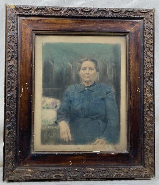 19th Century Print, Woman in Blue: A charming 19th-century print depicting a woman in a blue dress seated beside a table, presented in a period-appropriate frame. Measures approximately 25 1/4" x 29 1/2".