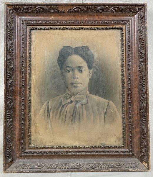 Charcoal Portrait of an African American Woman, Late 19th Century: A well-executed charcoal portrait of an African American woman, housed in a carved wood frame. Measures approximately 26" x 22 1/4" x 2" D. Some foxing and moisture damage to the paper, with loss to t