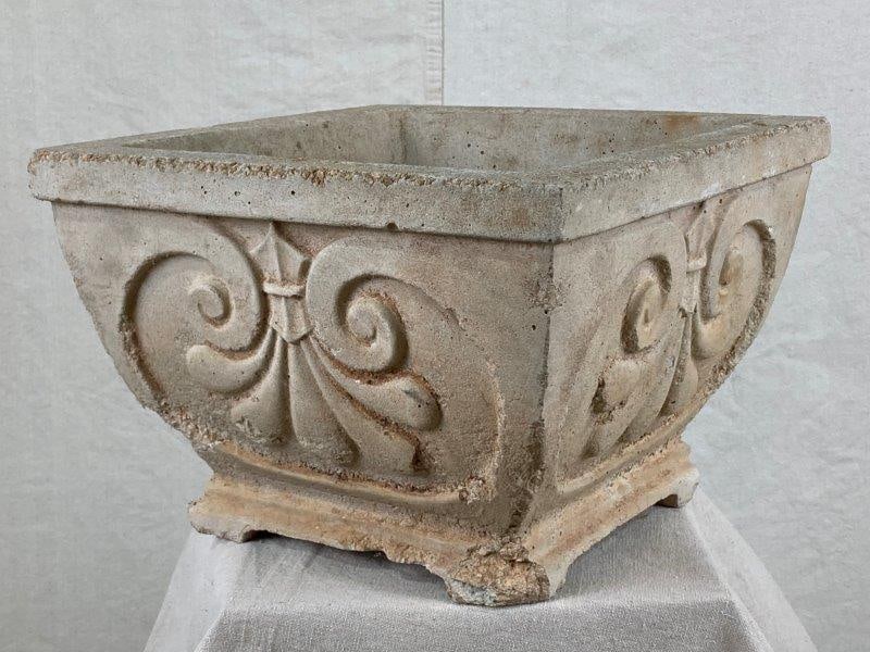 Fleur de Lis Concrete Planter: Decorative concrete planter featuring a Fleur-de-Lis motif in relief on each side, Measures approximately 9 1/8" H x 13 1/4" W x 13 3/8" D, Shows some surface loss.