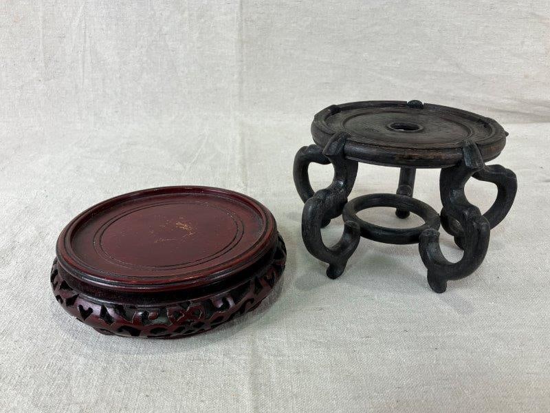 Two Chinese Carved Wood Stands: Chinese carved wood stands featuring richly toned dark wood surfaces and ornate decorative carving. The tallest measures approximately 4 1/4" H x 6" in diameter. Minor wear consistent with age.