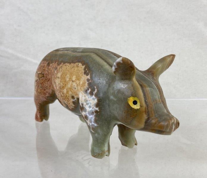 Banded Onyx Carved Pig Sculpture: Charming hand-carved pig sculpture crafted from layered banded onyx showcasing natural green, cream, and brown hues. Features finely carved details and painted yellow and black eyes for added characte
