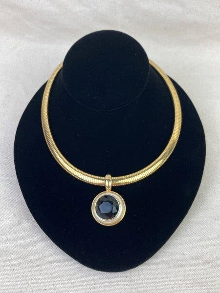 Vintage Marvella Gold Tone Necklace: Chic vintage Marvella gold-tone necklace featuring a central faceted faux black stone encircled by a ring of luminous faux pearl. The bold centerpiece rests on a sculptural gold chain, exemplifying cl