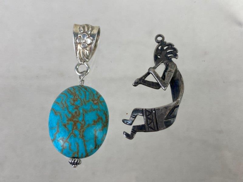 Sterling Silver Kokopelli and Turquoise Pendants: Pair of sterling silver pendants including one Kokopelli figure and one turquoise cabochon pendant, both marked 925 for silver content. The Kokopelli pendant measures approximately 1 1/2" H x 3/4" W x