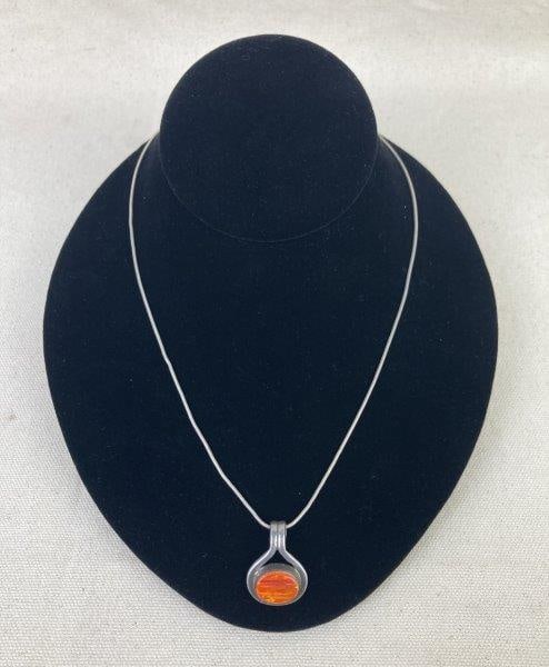 Artisan Sterling Silver and Art Glass Necklace: Beautiful artisan-crafted sterling silver necklace featuring an opalescent orange art glass pendant encased in sterling silver on a matching silver chain. Both the pendant and chain are marked for sil